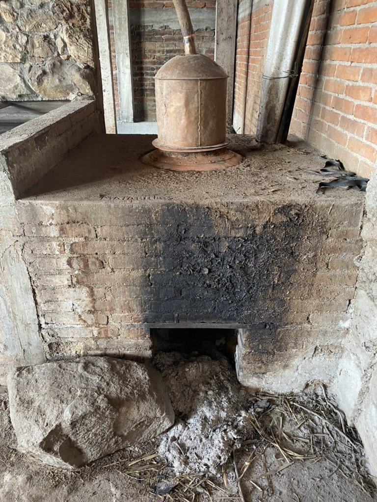 A copper pot still with wood fire underneath for making mezcal