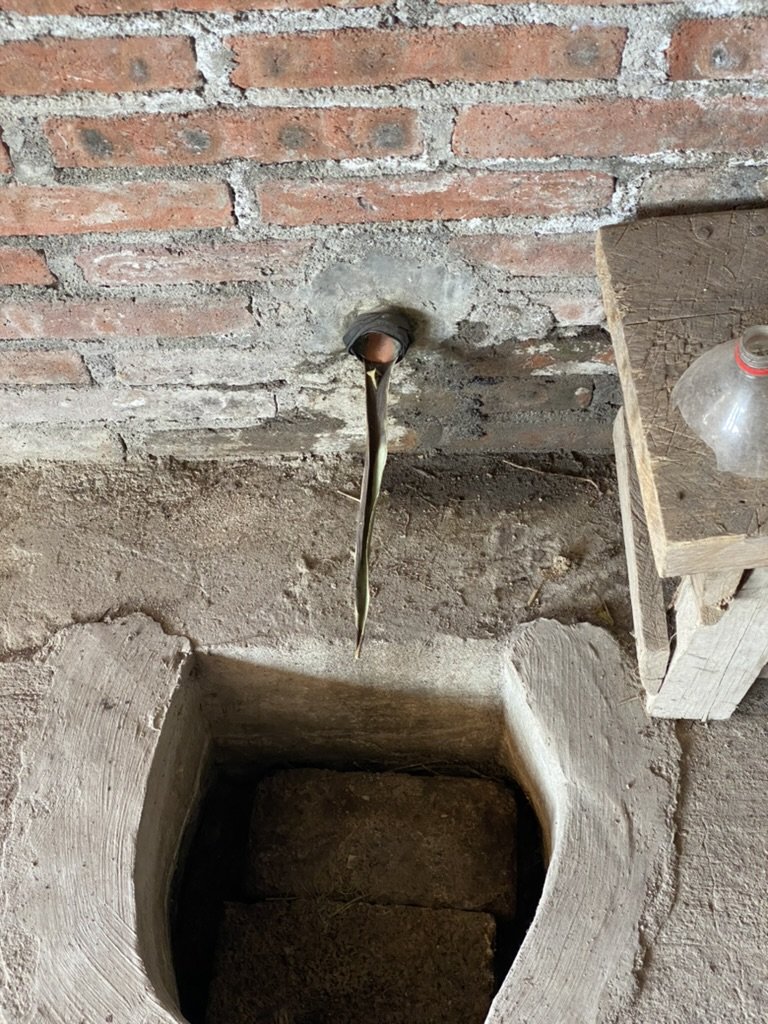 mezcal pouring from a tube in a wall down into a stone chamber