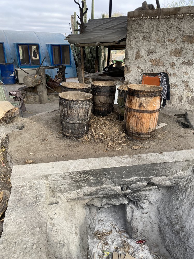 5 different tall clay pot boiling chambers are built into a stone oven with a single fire beneath them all.