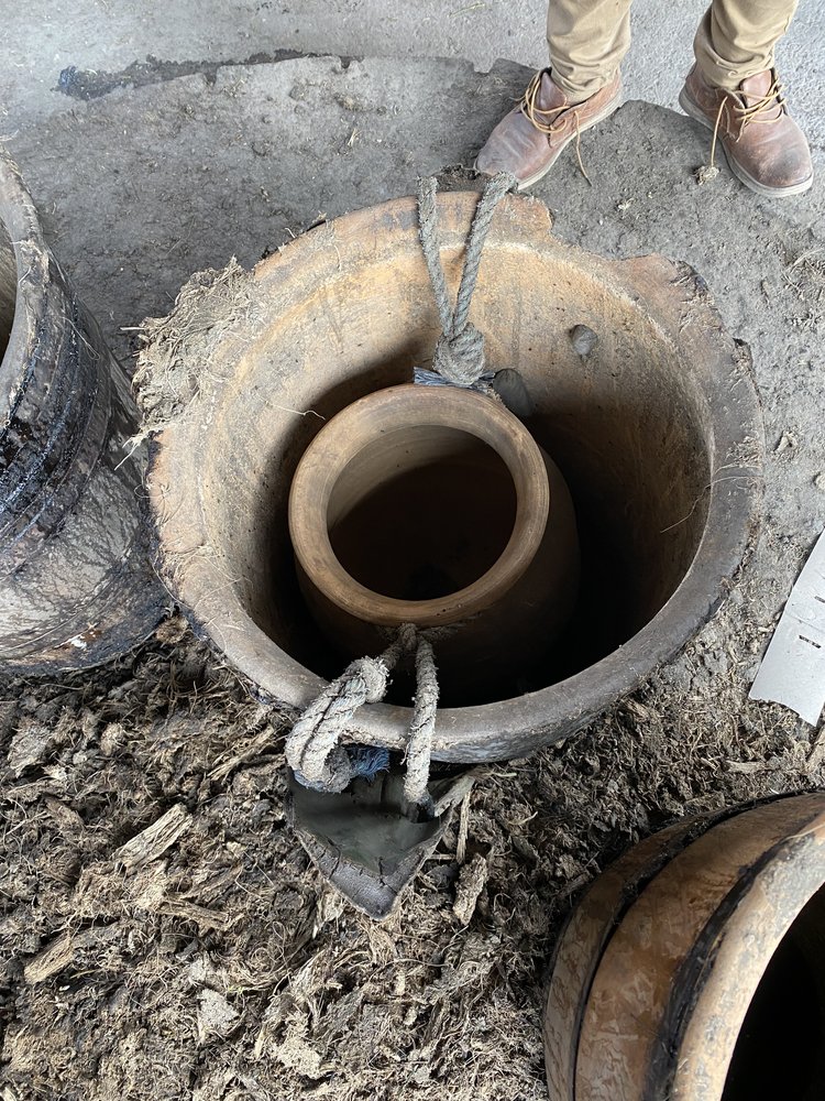 a smaller clay pot is suspended using the balancing weight of two agave leaves.